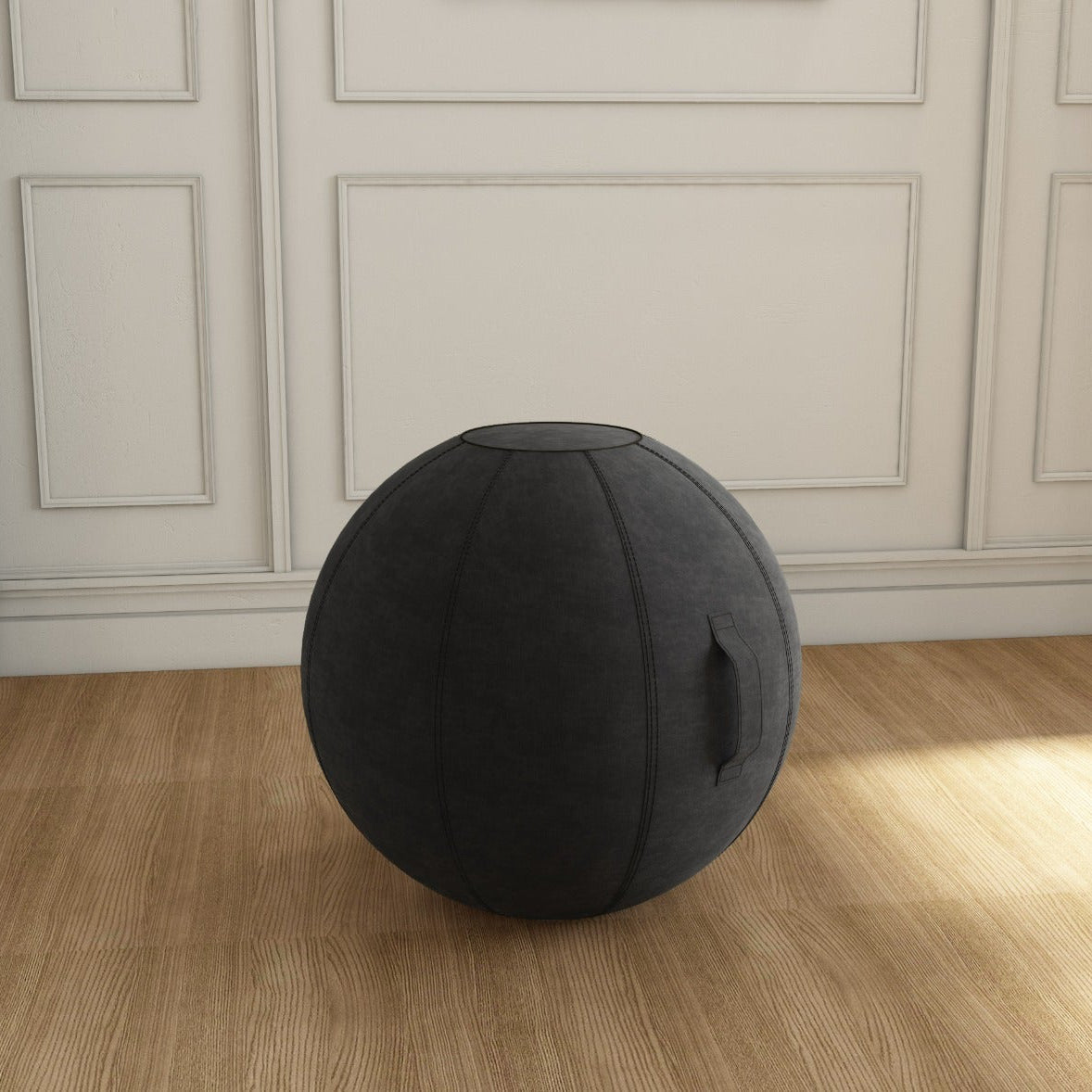 Black exercise ball on a wooden floor in a room with white paneled walls.
