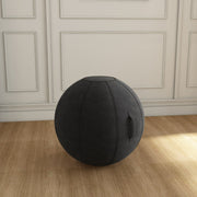 Black exercise ball on a wooden floor in a room with white paneled walls.